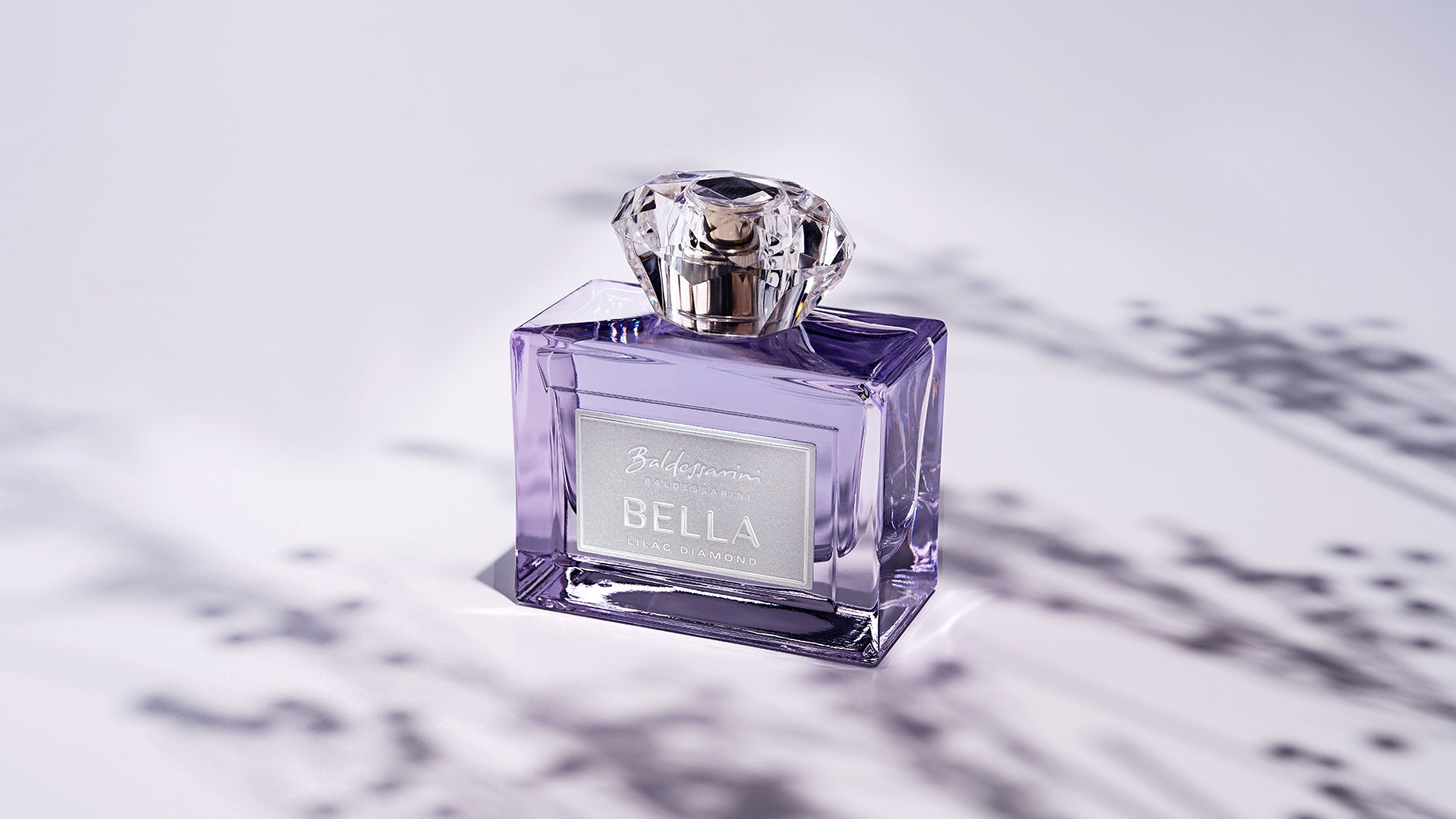 Baldessarini Bella Lilac Diamond Flakon mit Schatten im Hintergrund